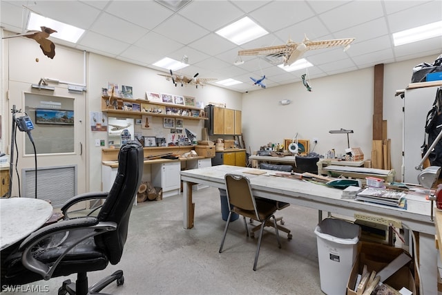 office with a drop ceiling and a workshop area