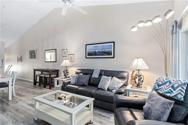 living room with ceiling fan, lofted ceiling, and light hardwood / wood-style flooring