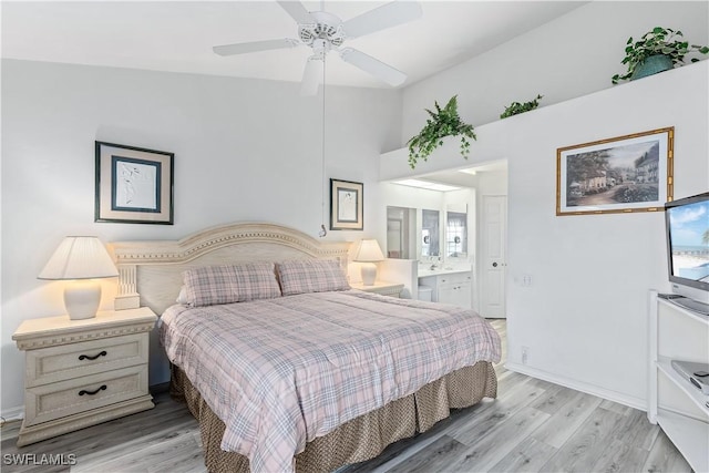 bedroom featuring ceiling fan, light hardwood / wood-style floors, and ensuite bath