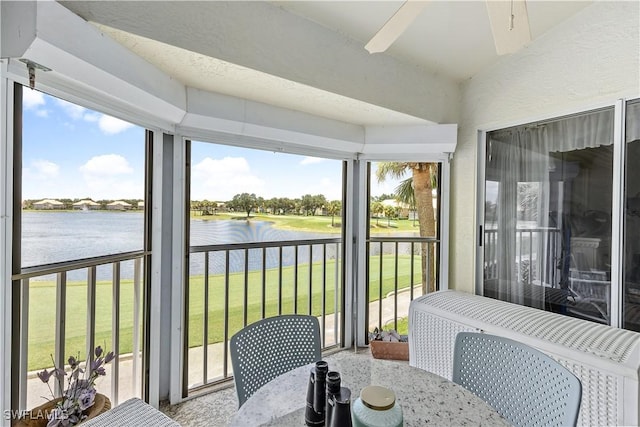 sunroom / solarium with lofted ceiling, plenty of natural light, and a water view