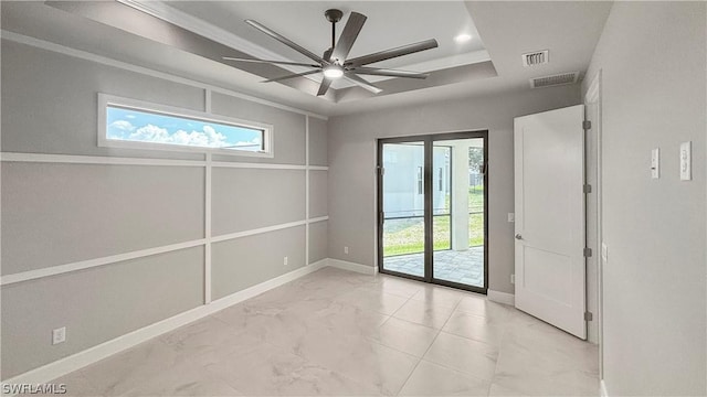 empty room featuring crown molding, ceiling fan, a healthy amount of sunlight, and a tray ceiling