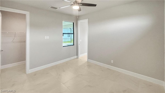 unfurnished bedroom with ceiling fan, a walk in closet, and a closet