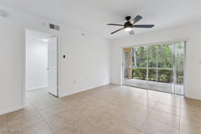 tiled empty room with ceiling fan