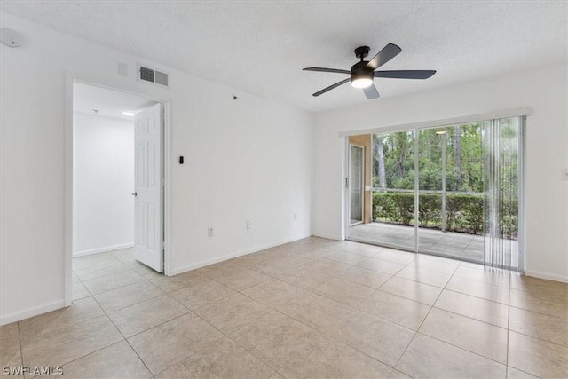 tiled spare room featuring a textured ceiling and ceiling fan