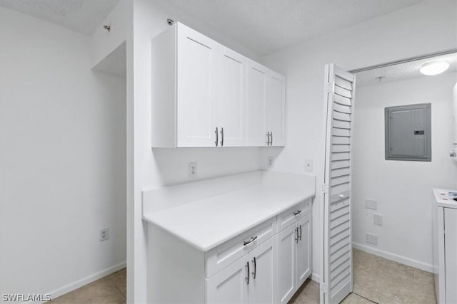 kitchen with light tile patterned floors, electric panel, and white cabinets