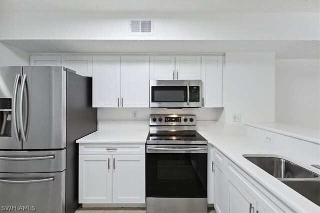 kitchen featuring white cabinetry, appliances with stainless steel finishes, and sink