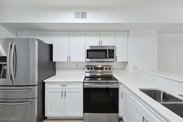 kitchen with white cabinetry, appliances with stainless steel finishes, and sink