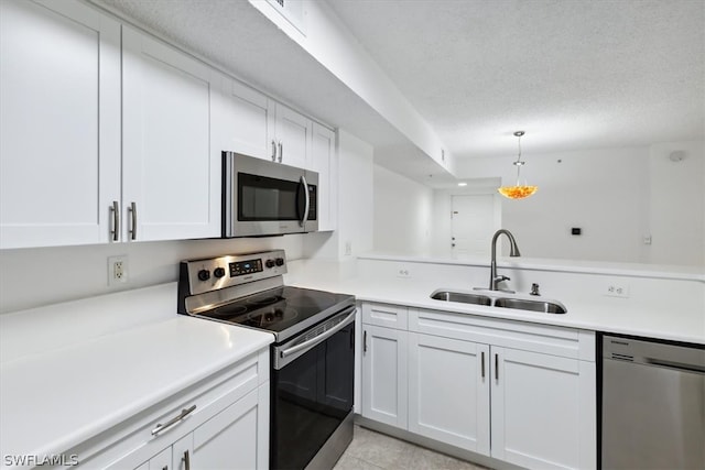 kitchen featuring light tile patterned flooring, a textured ceiling, white cabinets, appliances with stainless steel finishes, and sink