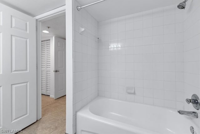 bathroom with tiled shower / bath combo and tile patterned floors