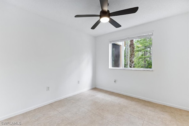 tiled spare room with ceiling fan