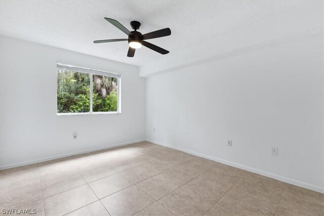 tiled empty room with a textured ceiling and ceiling fan