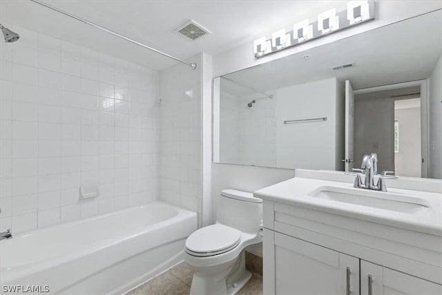 full bathroom with tiled shower / bath, tile patterned floors, toilet, and vanity