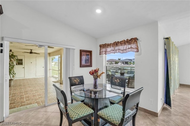 dining space with light tile patterned floors, vaulted ceiling, and ceiling fan