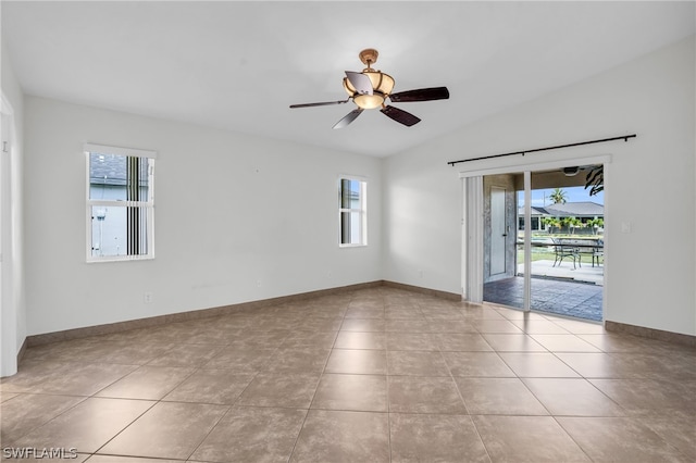 empty room featuring ceiling fan, a healthy amount of sunlight, and light tile patterned floors