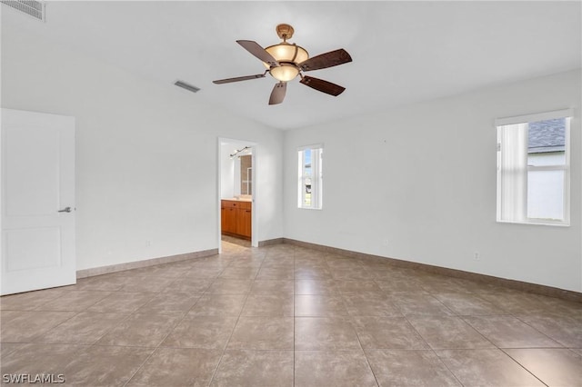 spare room with light tile patterned floors, vaulted ceiling, and ceiling fan