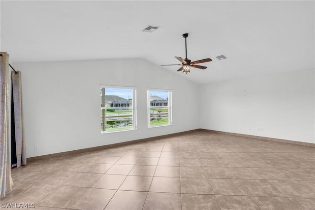 tiled empty room with vaulted ceiling and ceiling fan