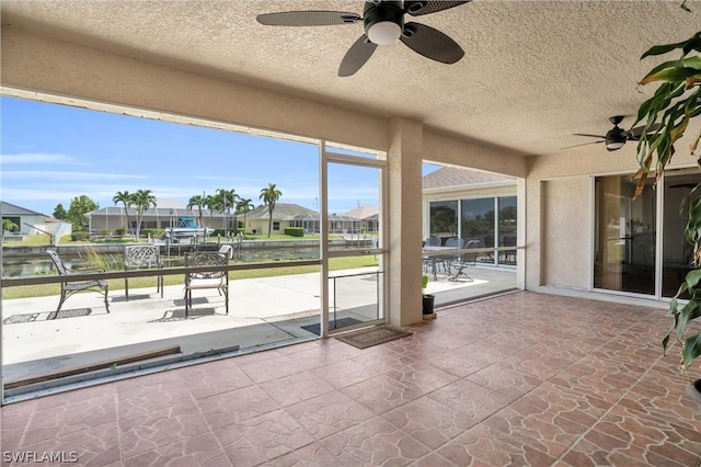 exterior space with a water view and ceiling fan