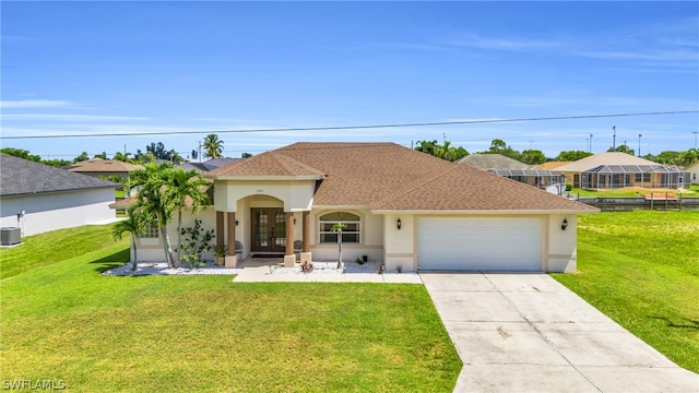 view of front of property featuring a garage, cooling unit, and a front lawn