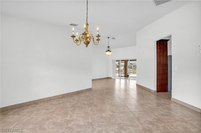 tiled spare room featuring a notable chandelier and french doors