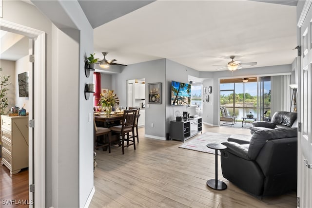 living room with light wood-type flooring and ceiling fan