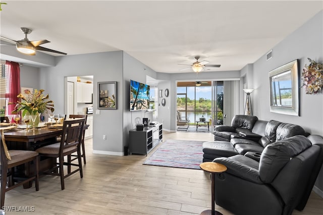 living room featuring light hardwood / wood-style floors and ceiling fan