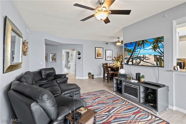 living room with ceiling fan and light hardwood / wood-style flooring