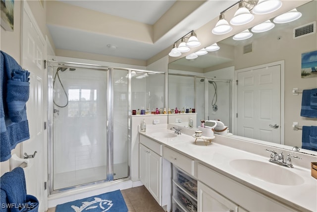 bathroom with tile patterned floors, vanity, and a shower with door