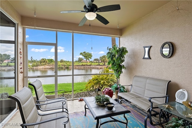 sunroom featuring ceiling fan and a water view