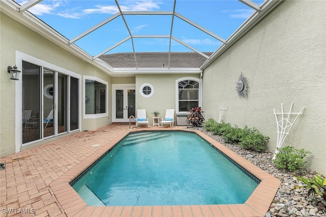 view of swimming pool featuring a lanai, a patio, and french doors