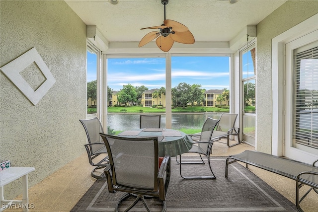 sunroom with ceiling fan, plenty of natural light, and a water view