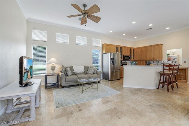 kitchen with sink, ceiling fan, ornamental molding, kitchen peninsula, and stainless steel appliances