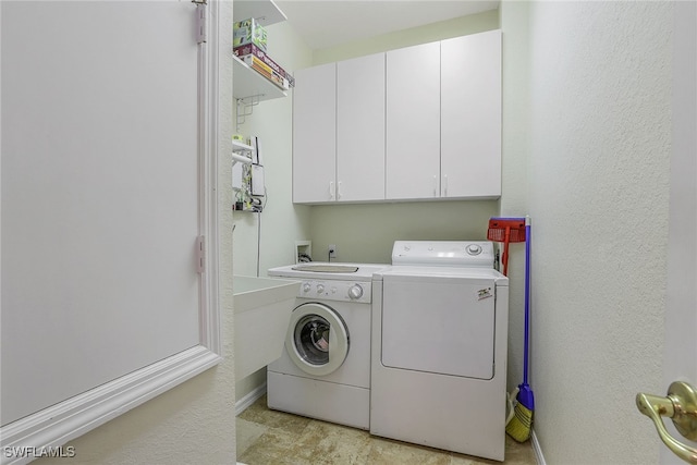 laundry room featuring cabinets and washing machine and dryer