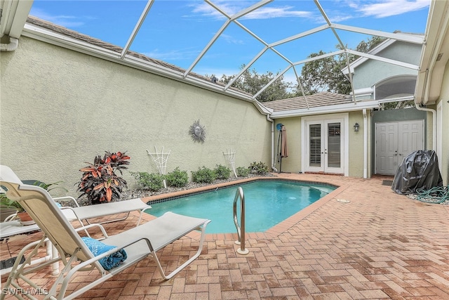 view of swimming pool featuring french doors, a lanai, and a patio area