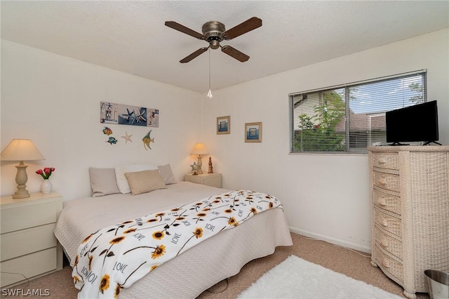 carpeted bedroom with a textured ceiling and ceiling fan