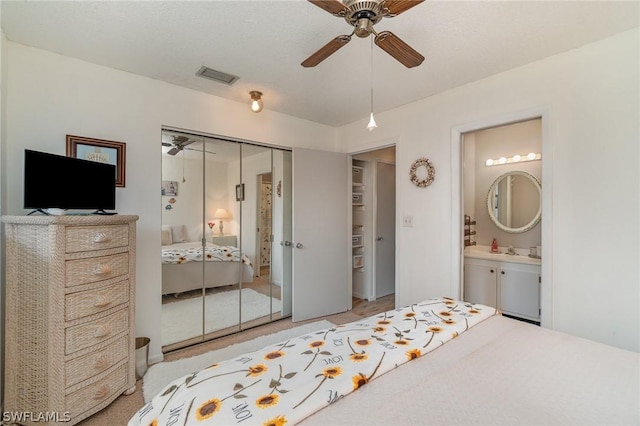 bedroom with a closet, ceiling fan, and ensuite bathroom