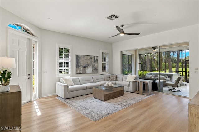 living room with light hardwood / wood-style floors and ceiling fan