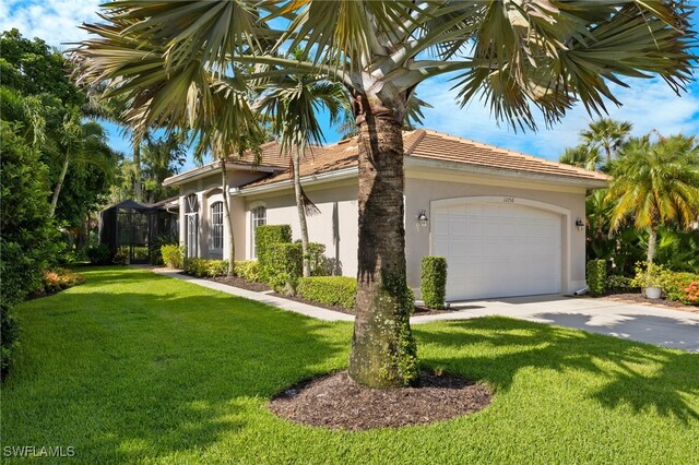 view of front of property with a garage and a front lawn