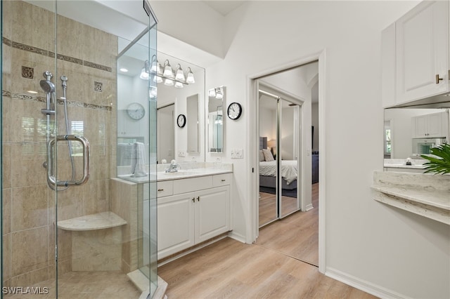 bathroom featuring vanity, a shower with door, and wood-type flooring