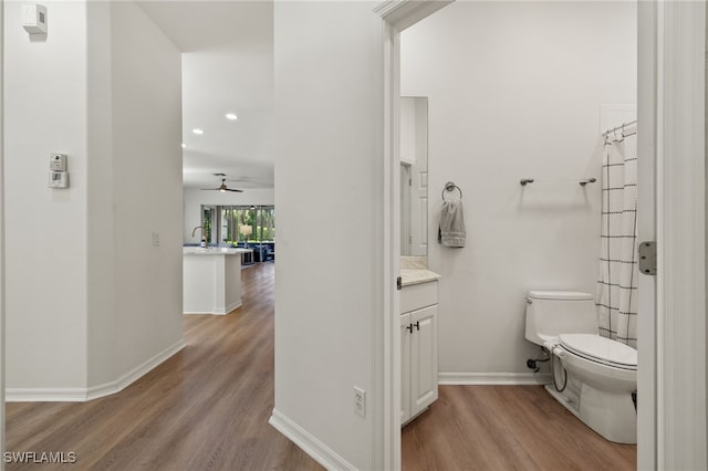 bathroom featuring vanity, ceiling fan, hardwood / wood-style flooring, and toilet