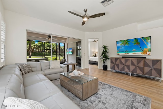 living room featuring light wood-type flooring and ceiling fan