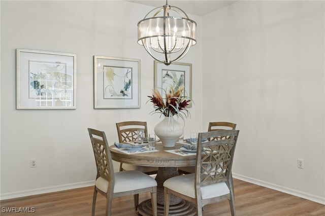 dining area with hardwood / wood-style floors and a chandelier