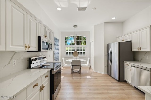 kitchen with decorative light fixtures, appliances with stainless steel finishes, light stone countertops, decorative backsplash, and white cabinets