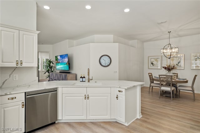 kitchen with light hardwood / wood-style floors, stainless steel dishwasher, light stone countertops, and kitchen peninsula