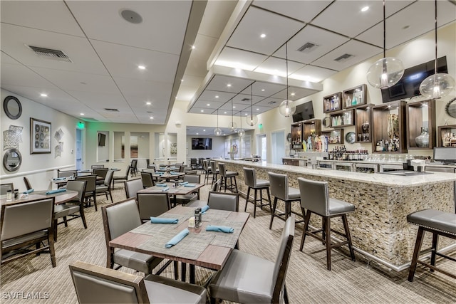 carpeted dining room featuring a paneled ceiling