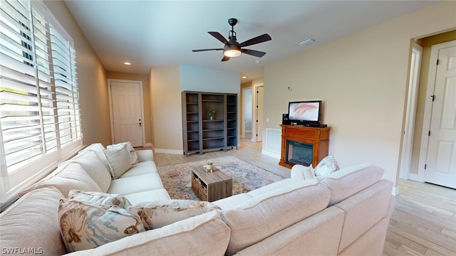 living room with light hardwood / wood-style flooring, a wealth of natural light, and ceiling fan