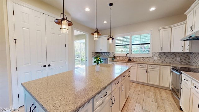 kitchen featuring sink, a kitchen island, decorative backsplash, and stainless steel appliances