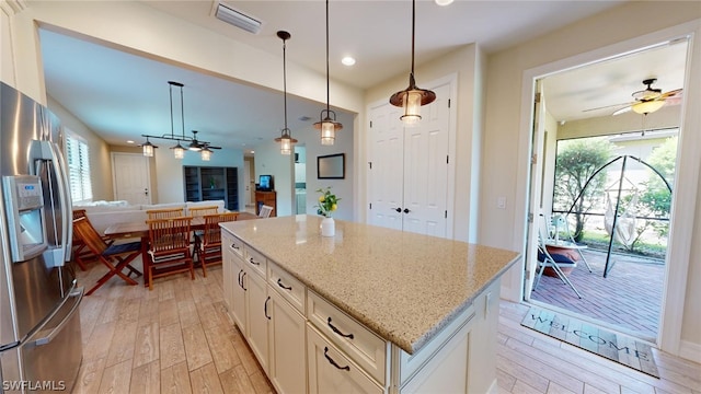 kitchen with white cabinetry, ceiling fan, stainless steel refrigerator with ice dispenser, pendant lighting, and light hardwood / wood-style flooring