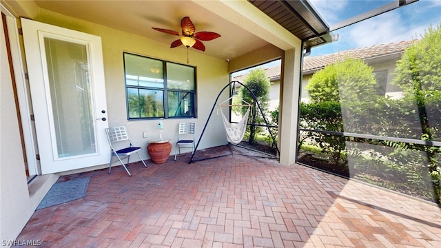 unfurnished sunroom with ceiling fan