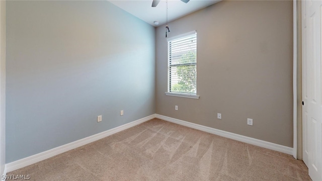 empty room with ceiling fan, lofted ceiling, and light colored carpet