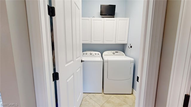 washroom featuring light tile patterned floors, separate washer and dryer, and cabinets